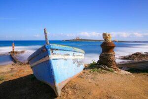 Barca e in sfondo Isola di Capo Passero. Foto Saverio Scala